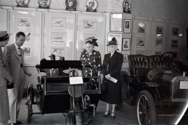 People admiring a 1901 Tri-Moto Crescent at the original Crawford Auto-Aviation Museum