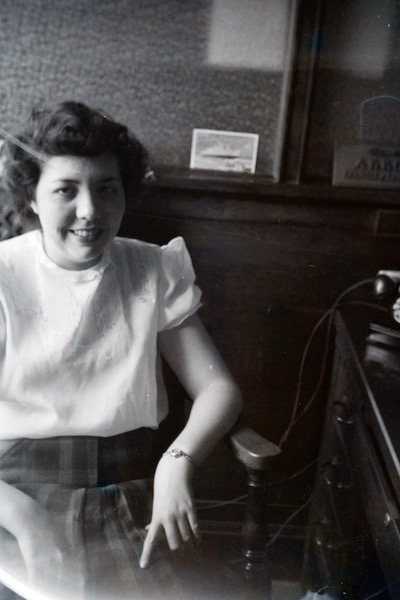 A woman sitting near the phone